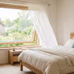 Schlafzimmer mit gekipptem Fenster und frischer Luft am Morgen